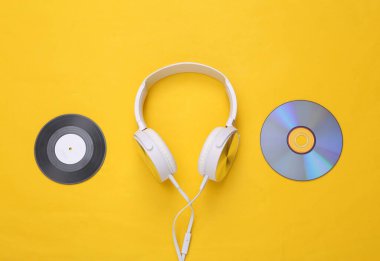 Müzikal tasarım. Kulaklıklar, plak kayıtları ve sarı arka planda CD 'ler. Üst Manzara. Düz yatıyordu