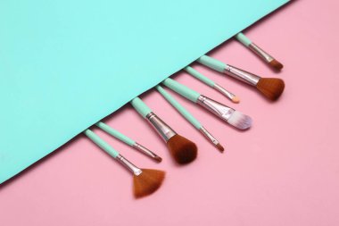 Makeup brushes on pink blue background. Beauty layout. Flat lay. Minimalism