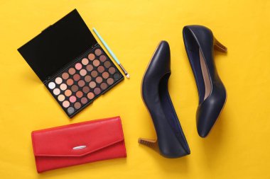 Kadın aksesuarlarının düz kompozisyonu, sarı arka planda kozmetik ürünleri. Üst görünüm