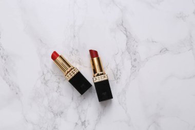 Red lipsticks on marble surface. Top view