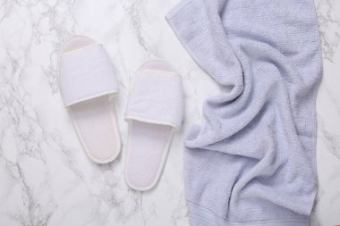 Bathroom hotel accessories. Towel and slippers on marble background