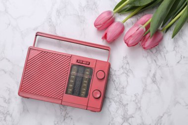 Pink tulips with fm radio on white marble surface. Romantic, music, love concept