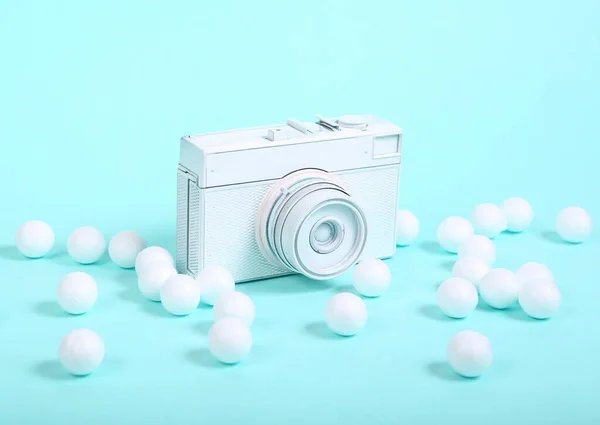 Film camera with white balls on blue background. Minimalism music still life. Creative layout