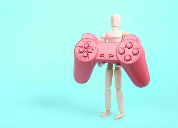 Holzpuppe Mit Rosa Gamepad Auf Blauem Hintergrund — Stockfoto