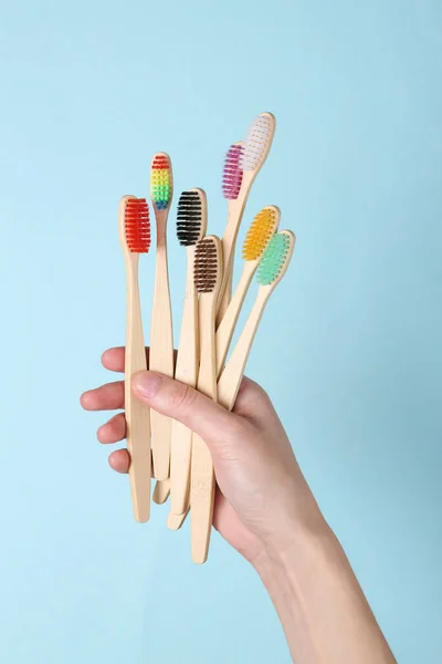 Handen Vasthouden Milieuvriendelijke Bamboe Tandenborstels Blauwe Achtergrond Tandheelkundige Verzorging — Stockfoto