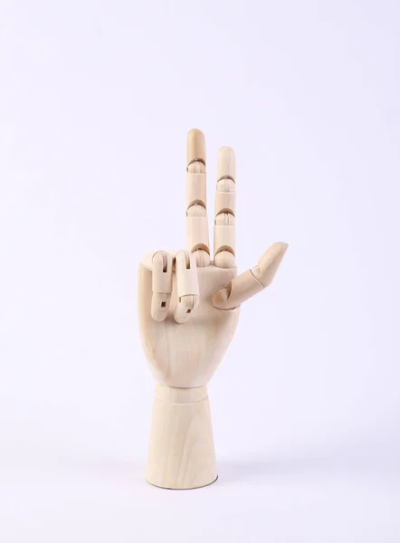wooden puppet hand shows the peace symbol raised two fingers up on white background