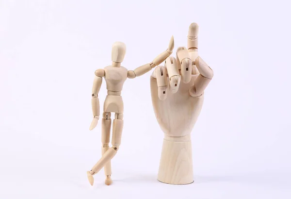 Wooden puppet and hand on white background