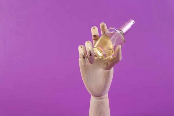 Botella Perfume Mano Madera Sobre Fondo Púrpura — Foto de Stock