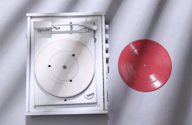 Gri arka planda beyaz vinil plak çalar ve son moda çizgili gölge. DJ ekipmanları. Minimalizm müzik konsepti. Yaratıcı yerleşim