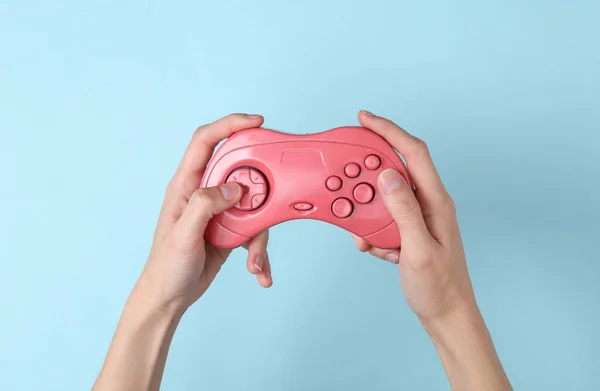 Női Kéz Tart Egy Rózsaszín Retro Gempad Kék Háttér Játékkoncepció — Stock Fotó