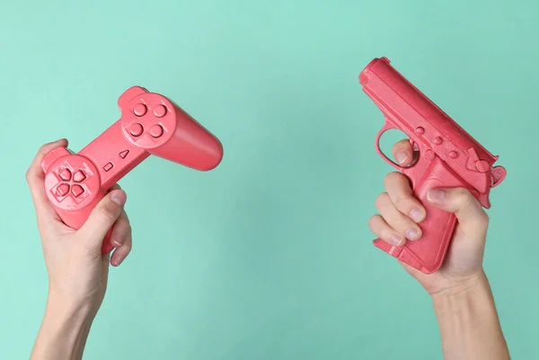 女性の手は青を背景にピンクのレトロなジェンパドと銃を保持します レトロゲーム — ストック写真