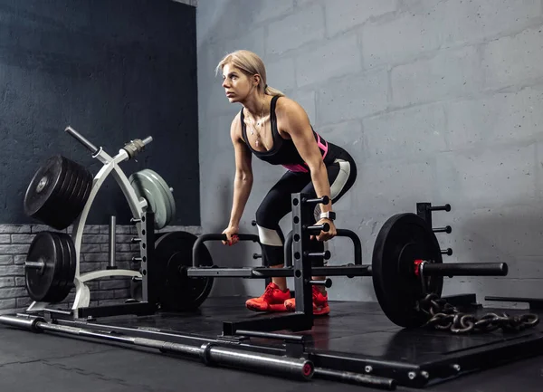 在健身房举重锻炼的女人 用杠铃配合女性做举重运动 — 图库照片