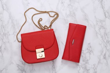 Mermer yüzeyde kırmızı deri cüzdan ve çanta.