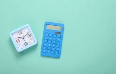 Mavi arka planda hesap makinesi ve alarm saati. Üst görünüm