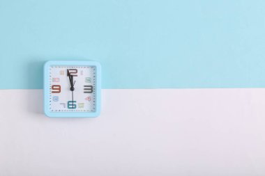 Beyaz mavi arka planda kare alarm saati. Üst görünüm