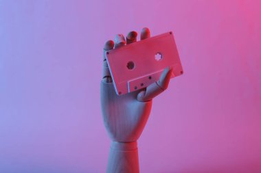 Tahta el, pembe mavi renkli neon ışıklı ses kasetini tutuyor.