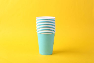 Sarı arka planda boş kahve fincanları yığını