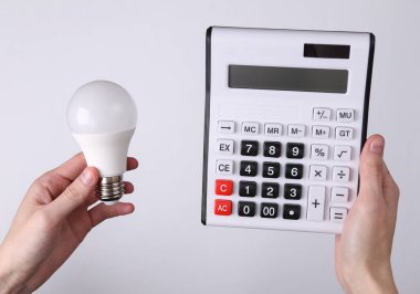 Gri arkaplanda el bilgisayarı ve ampulü tutar