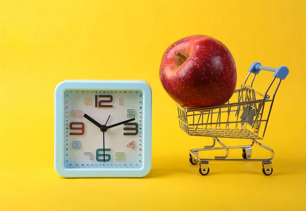 Carro Supermercado Con Manzana Reloj Sobre Fondo Amarillo —  Fotos de Stock