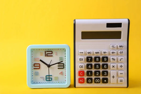 黄色背景上的计算器和时钟 — 图库照片