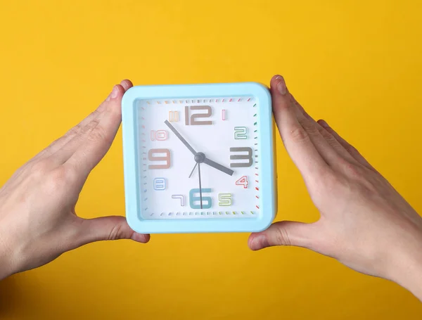 Hands Hold Alarm Clock Yellow Background — 图库照片