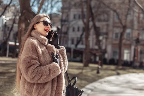 Молодая Привлекательная Блондинка Одетая Шубу Солнцезащитные Очки Разговаривает Телефону Городе — стоковое фото