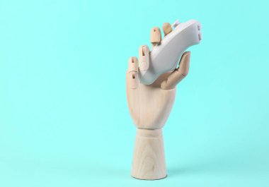 Ahşap el mavi arka planda modern kontrol mekanizmasını tutuyor