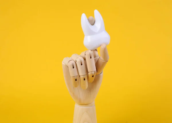 Mão Madeira Segura Dente Fundo Amarelo — Fotografia de Stock