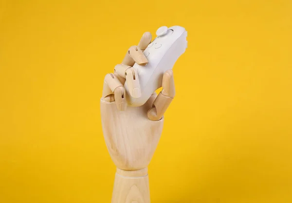 Ξύλινο Χέρι Κρατά Σύγχρονο Ελεγκτή Κίτρινο Φόντο — Φωτογραφία Αρχείου
