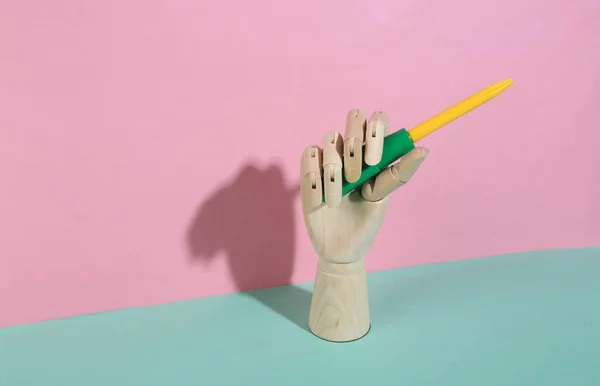 Tangan Kayu Memegang Obeng Mainan Pada Latar Belakang Pastel Biru — Stok Foto