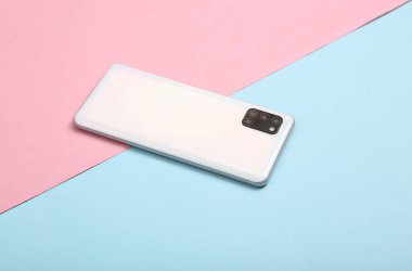 Modern akıllı telefonun arka tarafında mavi renkli pastel arka planda dört kamera var.