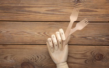 Tahta el, tahta arka planda çatalları tutuyor.