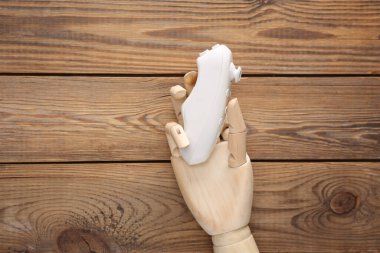 Tahta el, ahşap arka planda modern joystick tutuyor.