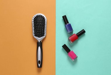 Renkli kağıtta tırnak cilası şişeleri ve saç fırçası. Güzellik hayattır