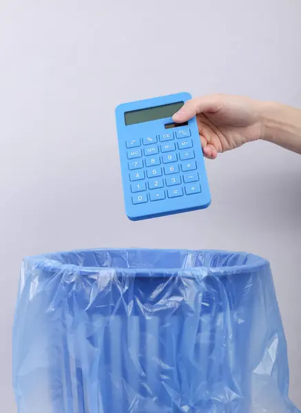 Hand Gooit Calculator Prullenbak Met Pakket Grijze Achtergrond — Stockfoto