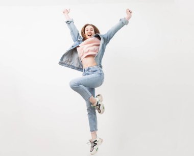 Neşeli enerjik kadın beyaz arka planda izole bir şekilde zıplıyor..