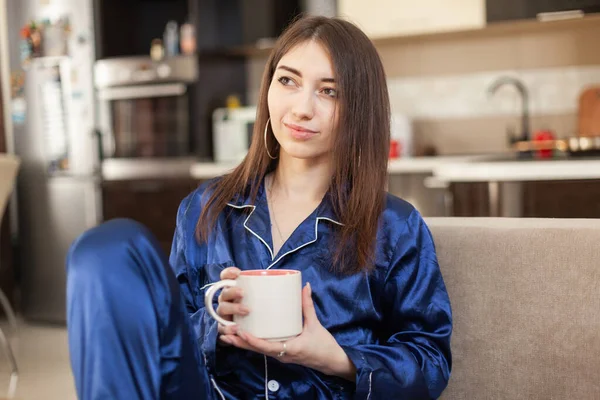 Mujer Joven Camisón Bebe Café Mira Televisión Mientras Sienta Sofá —  Fotos de Stock