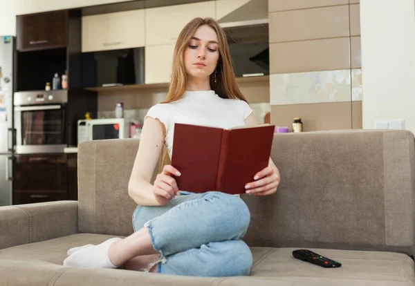 Mladá Žena Čtení Knihy Zatímco Sedí Pohovce Obývacím Pokoji — Stock fotografie