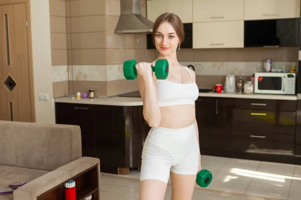 Ung Leende Kvinna Tränar Biceps Med Hantlar Händerna Vardagsrummet — Stockfoto