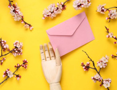 El ele tutuşmalar ve sarı arka planda güzel çiçek dalları. Düz yatış, üst görünüm.