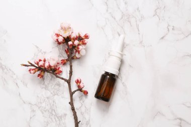 Mermer zemin üzerinde güzel çiçekli burun spreyi. İlkbahar konsepti. Düz yatış, üst görünüm