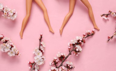 Bebek bacakları ve pembe arka planda çiçek açan güzel dallar. İlkbahar, güzellik konsepti. Düz yatış, üst görünüm.