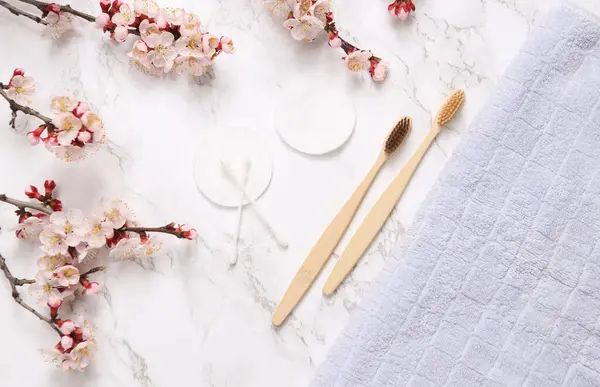 Kişisel bakım, hijyen malzemeleri, mermer arka planda güzel çiçek dalları.