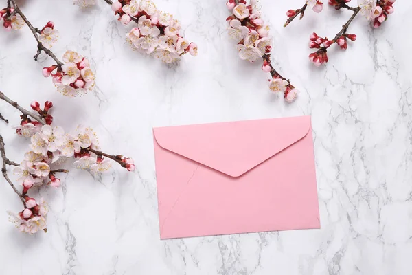 Zarf ve mermer arka planda güzel çiçekli dallar. Düz yatış, üst görünüm.