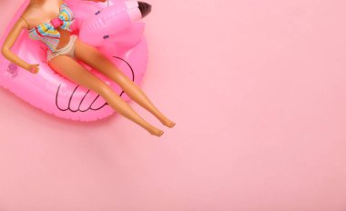 Mayo giymiş bebek şişme flamingoda dinleniyor. Yaz tatili, plaj partisi. 