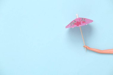 Mavi pastel arka planda şemsiye tutan bebek. Minmalizm, konsept sanat. Boşluğu kopyala