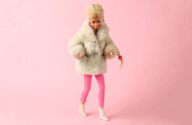 ODESSA, UKRAINE - 1 Haziran 2021: Kürk ceketli Barbie Bebek ve pembe arka planda ayakkabılar. Minimalizm moda düzeni. Üst Manzara. Düz yatıyordu