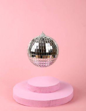 Pembe arka planda podyumu olan disko topu. Minimalizm partisi konsepti