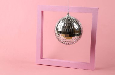 Pembe arka planda çerçeveli disko topu. Minimalizm partisi konsepti