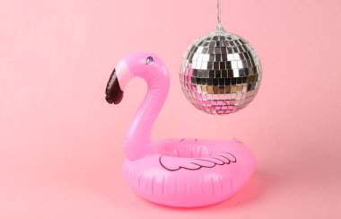 Disko topunun altında pembe arka planda şişme flamingo. Minimalizm partisi konsepti